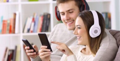 couple listening to music headphones mobile featured 1000x500