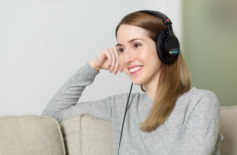 mujer sentada escucha audifonos