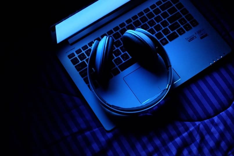 Audifonos sobre una portatil con tono azul